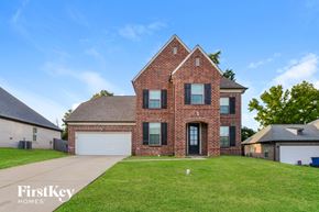 Olive Branch house for rent - A brick house with a large front yard and a clear blue sky.