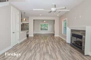 Olive Branch house for rent - A spacious living room with a fireplace and a ceiling fan.