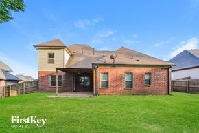 Olive Branch house for rent - A house with a brown brick exterior and a white house in the background.