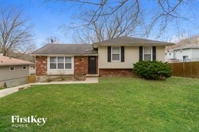 Kansas City house for rent - a small brick house with a yard and a fence