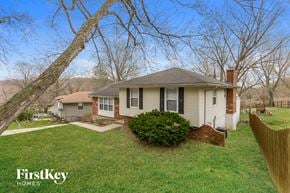 Kansas City house for rent - a small white house with a yard and a tree