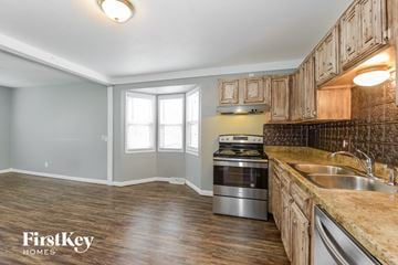 Kansas City house for rent - a kitchen with wooden cabinets and stainless steel appliances