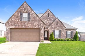 Olive Branch house for rent - a brick house with a garage and a green lawn