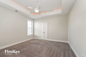 Olive Branch house for rent - an empty living room with a ceiling fan and a door