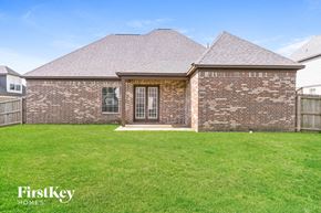 Olive Branch house for rent - a small brick house with a grassy yard