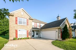 Indianapolis house for rent - a brick house with red shutters and a white garage door