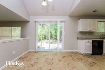 Lithonia house for rent - A kitchen area with a black dishwasher and a window with blinds.