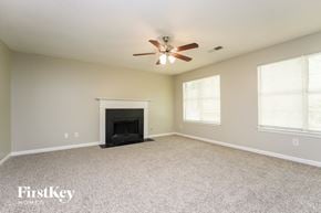 Lithonia house for rent - A spacious living room with a fireplace and a ceiling fan.
