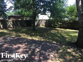 Memphis house for rent - a backyard with shady trees and a fence
