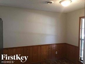 Memphis house for rent - a dining room with wood paneling and a white wall