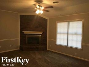 Memphis house for rent - a living room with a fireplace and a ceiling fan