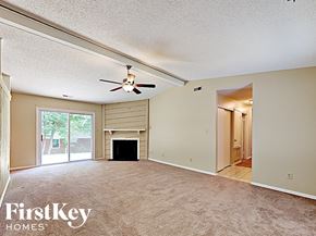 Charlotte house for rent - A spacious living room with a fireplace and sliding glass doors.