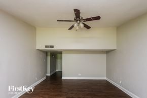Garland house for rent - A spacious room with a ceiling fan and wooden flooring.