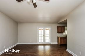 Garland house for rent - A room with a white ceiling and wooden floors with a kitchen area in the background.