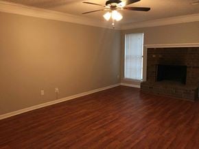 Memphis house for rent - a living room with a fireplace and a ceiling fan