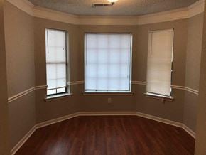 Memphis house for rent - a dining room with a hard wood floor and three windows