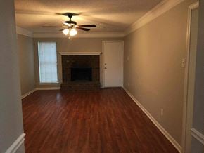 Memphis house for rent - an empty living room with a ceiling fan and a fireplace
