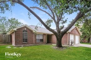 Katy house for rent - a small brick house with a tree in the yard
