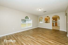 Riverview house for rent - A spacious room with wooden flooring and a large window.