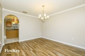 Riverview house for rent - A large empty room with a chandelier and a logo that says "FirstKey Homes".