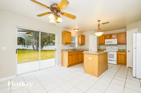 Riverview house for rent - A kitchen with a white ceiling fan and wooden cabinets.
