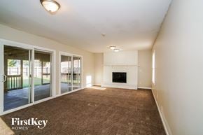 Indianapolis house for rent - an empty living room with a fireplace and glass sliding doors