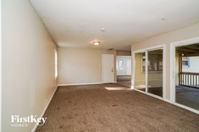 Indianapolis house for rent - a living room with a carpeted floor and sliding glass doors