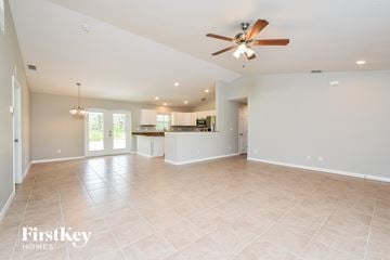 Port Charlotte house for rent - A spacious living room with a ceiling fan and lighting fixtures.