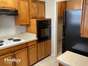 Watauga house for rent - A kitchen with wooden cabinets and black appliances.