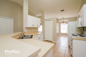 Fort Myers house for rent - a large kitchen with white cabinets and a sink