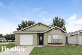 Orlando house for rent - A small house with a garage door and a window is for sale.