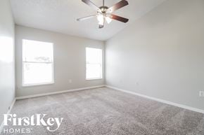 Orlando house for rent - A spacious room with a ceiling fan and two windows.