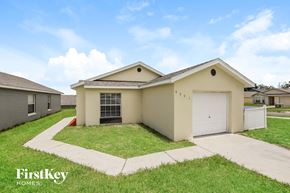Orlando house for rent - a beige house with a garage and a lawn