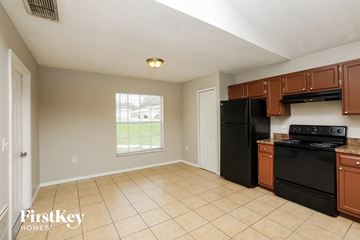 Orlando house for rent - a kitchen with black appliances and brown cabinets