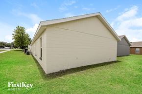 Orlando house for rent - the side of a small white building with a green lawn