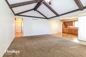 Grandview house for rent - an empty living room with white walls and wood beams