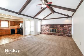Grandview house for rent - a living room with a brick fireplace and a carpeted floor