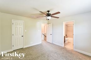 San Antonio house for rent - a bedroom with a ceiling fan and a door to a bathroom