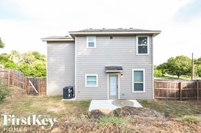 San Antonio house for rent - the exterior of a tiny house in a backyard with a wooden fence