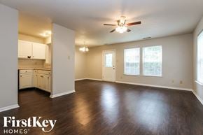 Indianapolis house for rent - A spacious room with wooden floors and a ceiling fan.
