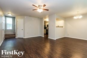 Indianapolis house for rent - A spacious room with a ceiling fan and wooden flooring.