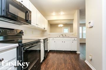 Indianapolis house for rent - A kitchen with white cabinets and black appliances.