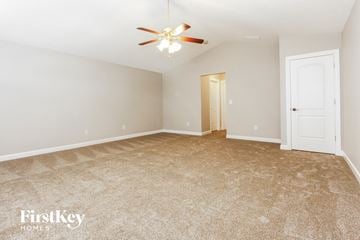 Indianapolis house for rent - a spacious living room with carpet and a ceiling fan