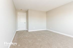 Indianapolis house for rent - a spacious bedroom with carpet and a white door