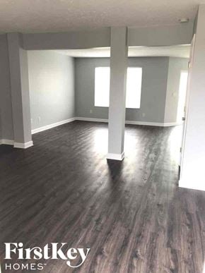 Morrow house for rent - an empty living room with gray walls and wood floors
