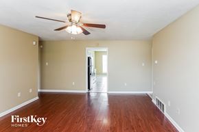 Horn Lake house for rent - A room with a ceiling fan and wooden floors.