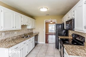 Horn Lake house for rent - A kitchen with granite countertops and black appliances.