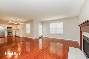 Westerville house for rent - an empty living room and kitchen with wood floors