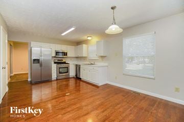Westerville house for rent - a kitchen with a wooden floor and a stainless steel refrigerator