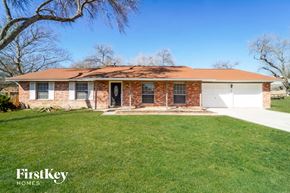 San Antonio house for rent - a brick house with a lawn and a white garage